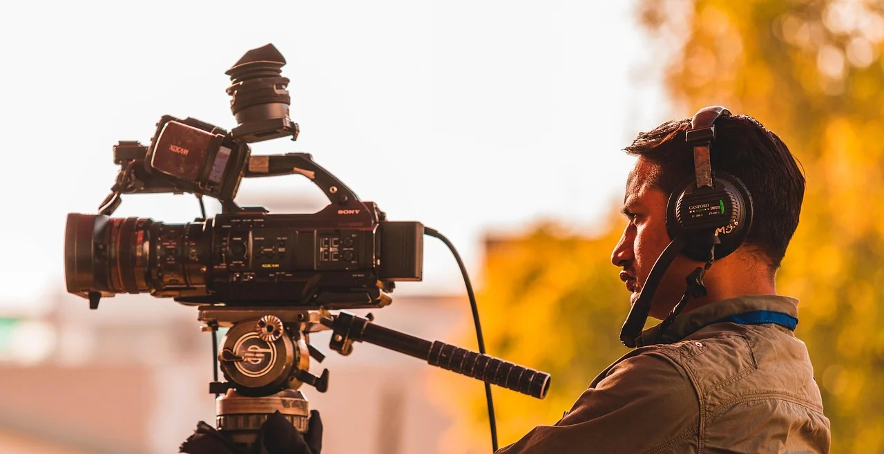 Filmmaker operating a cinema camera in warm evening light